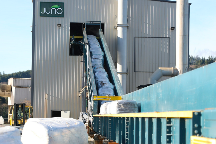 Large bales of shredded garbage coming up a conveyor belt into the Juno facility