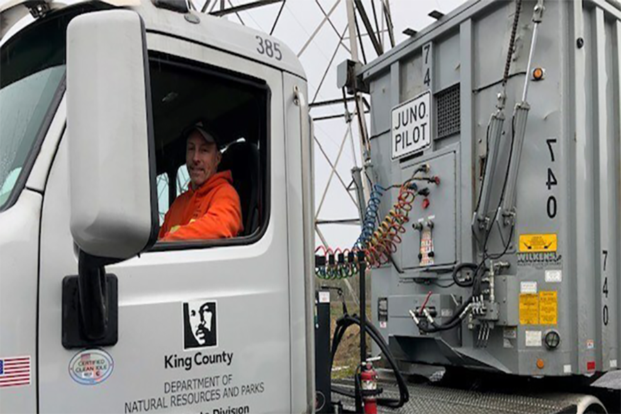 Man driving a King County truck with an attached container labeled ‘Juno Pilot’